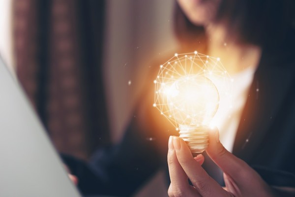 Person holding a light bulb that is lite up.