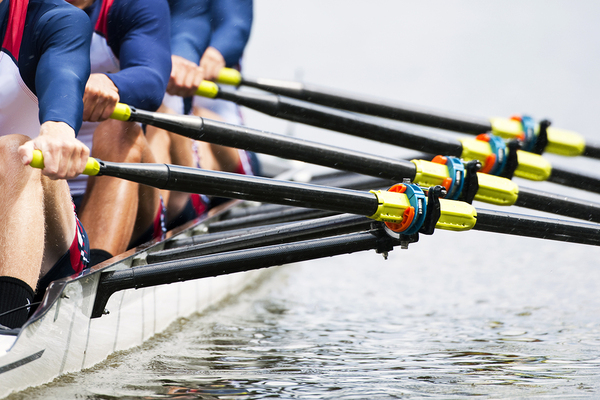 Team of people rowing in a boat