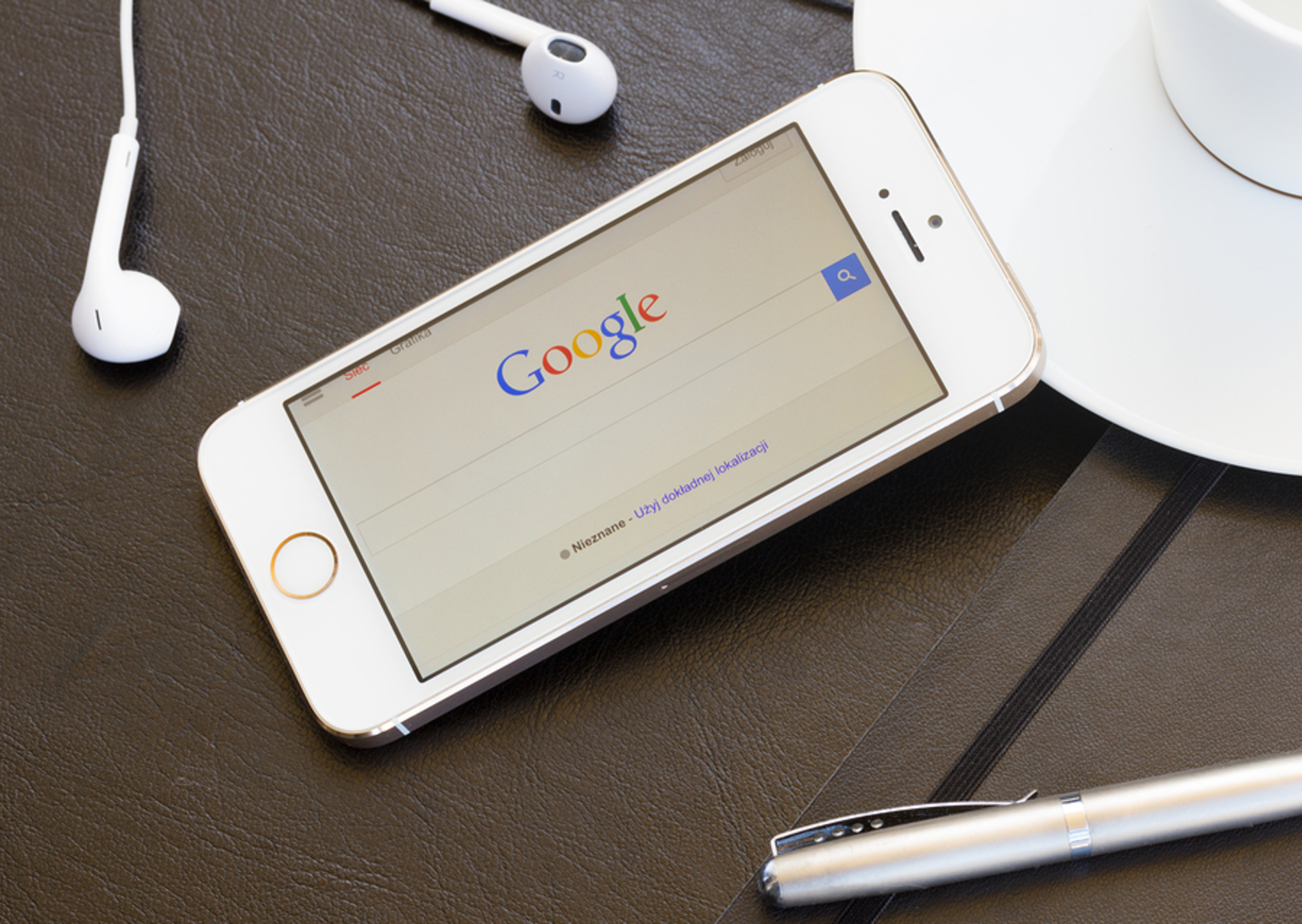 Mobile phone with the Google search bar displayed. Mobile phone with the Google search bar displayed.