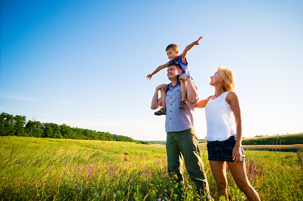 Family outside in a green pasture.