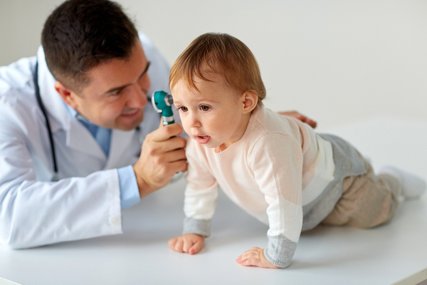 Pediatrician doing an ear exam on a toddler 