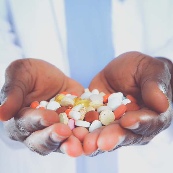 Person holding a pile of pills in their cupped hands.
