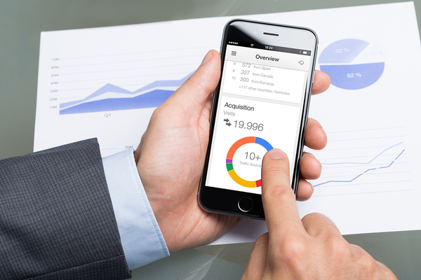 Image of businessman using Google Analytics on mobile phone.