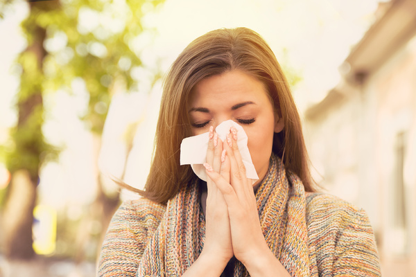 Using a tissue to wipe your nose.