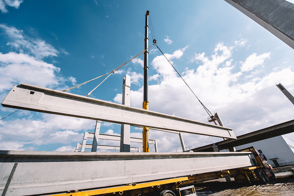 Industrial heavy duty crane lifting large metal pieces.