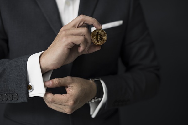 Man holding a golden bitcoin coin.