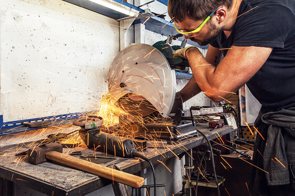Sparks from a man cutting with a saw
