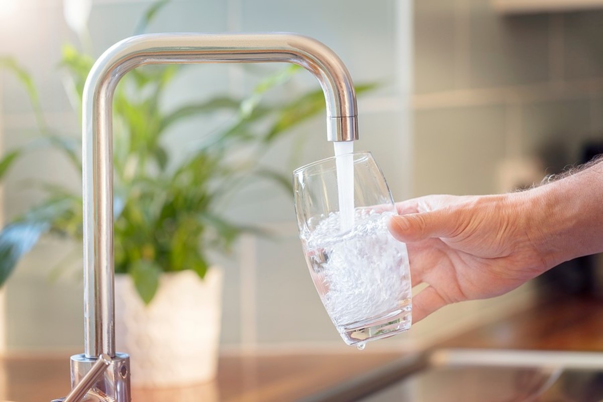 Person filling a glass with tap water