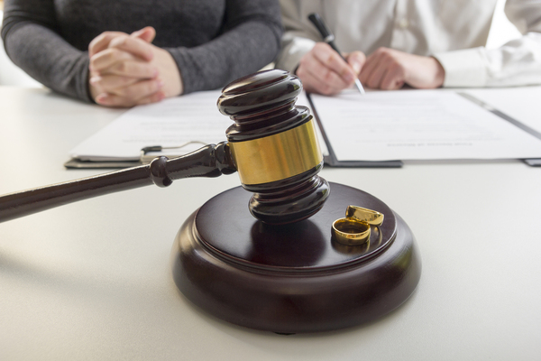 Judge's gavel with two wedding rings.