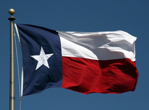 Texas state flag with blue sky in the background.