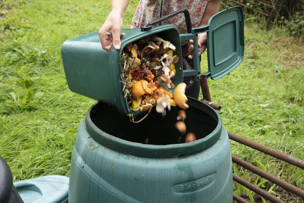 Pouring compostable foods into a container.