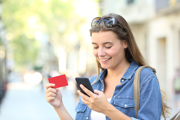 Woman making a purchase with a credit card on her phone.