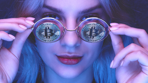 Woman wearing glasses with gold bitcoin coins.