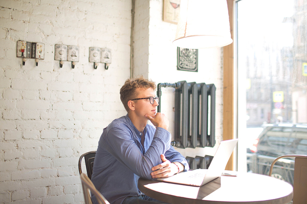 Man sitting at a table with a laptop.