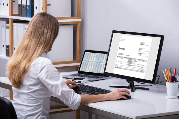 Woman working at a desk with a desktop computer.