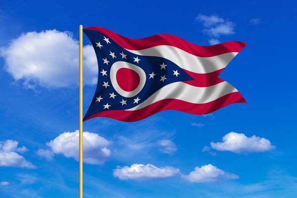 Ohio flag waving with a blue sky in the background