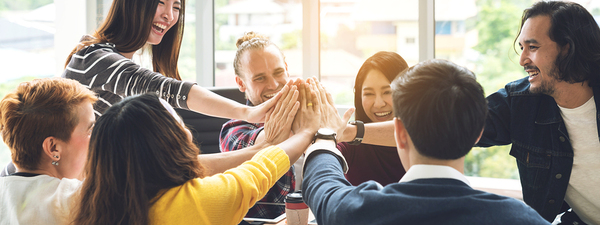 Group of colleagues placing hands together around a circle.