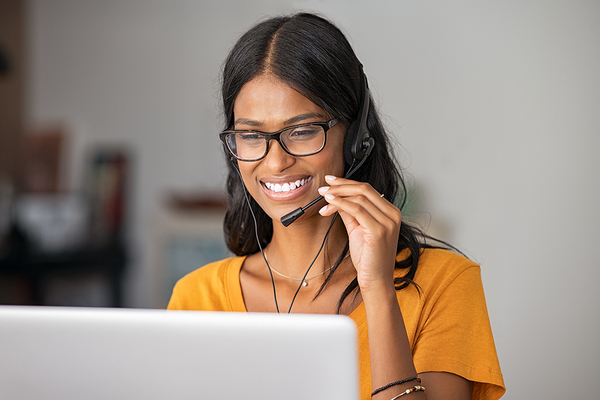 Woman using a headset while sitting in front of her laptop computer.