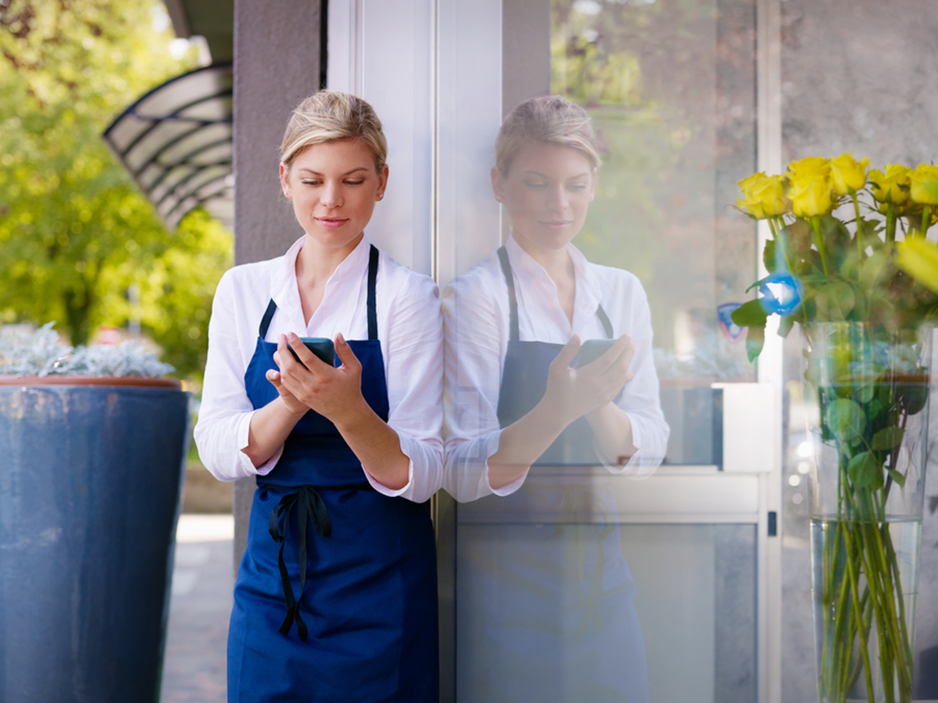 Woman standing outside looking at her phone. Woman standing outside looking at her phone.