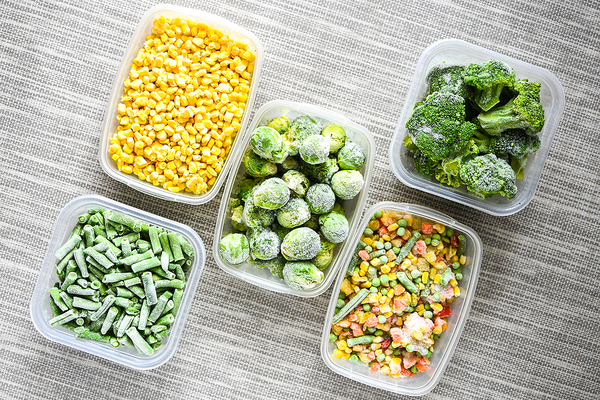 Plastic bowls filled with vegetables.