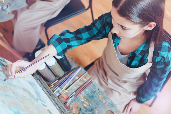 Teen painting on a canvas.