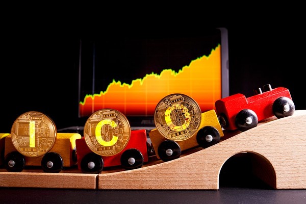 Toy train with gold bitcoins spelling out ICO.