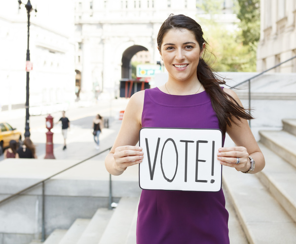 Woman holding a Vote sign.