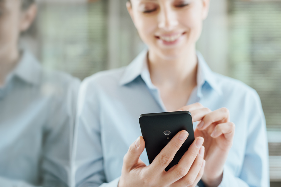 Image of woman using smartphone. Attractive website and mobile design paired with effective inbound marketing strategies can help drive conversions.