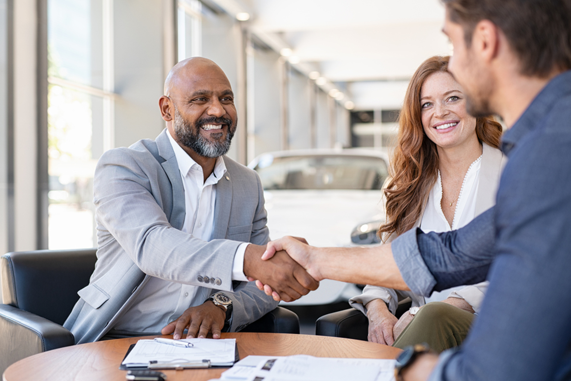 Man shaking hands with a car dealer.