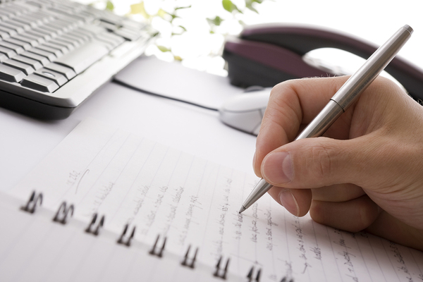 a hand writing in a notebook